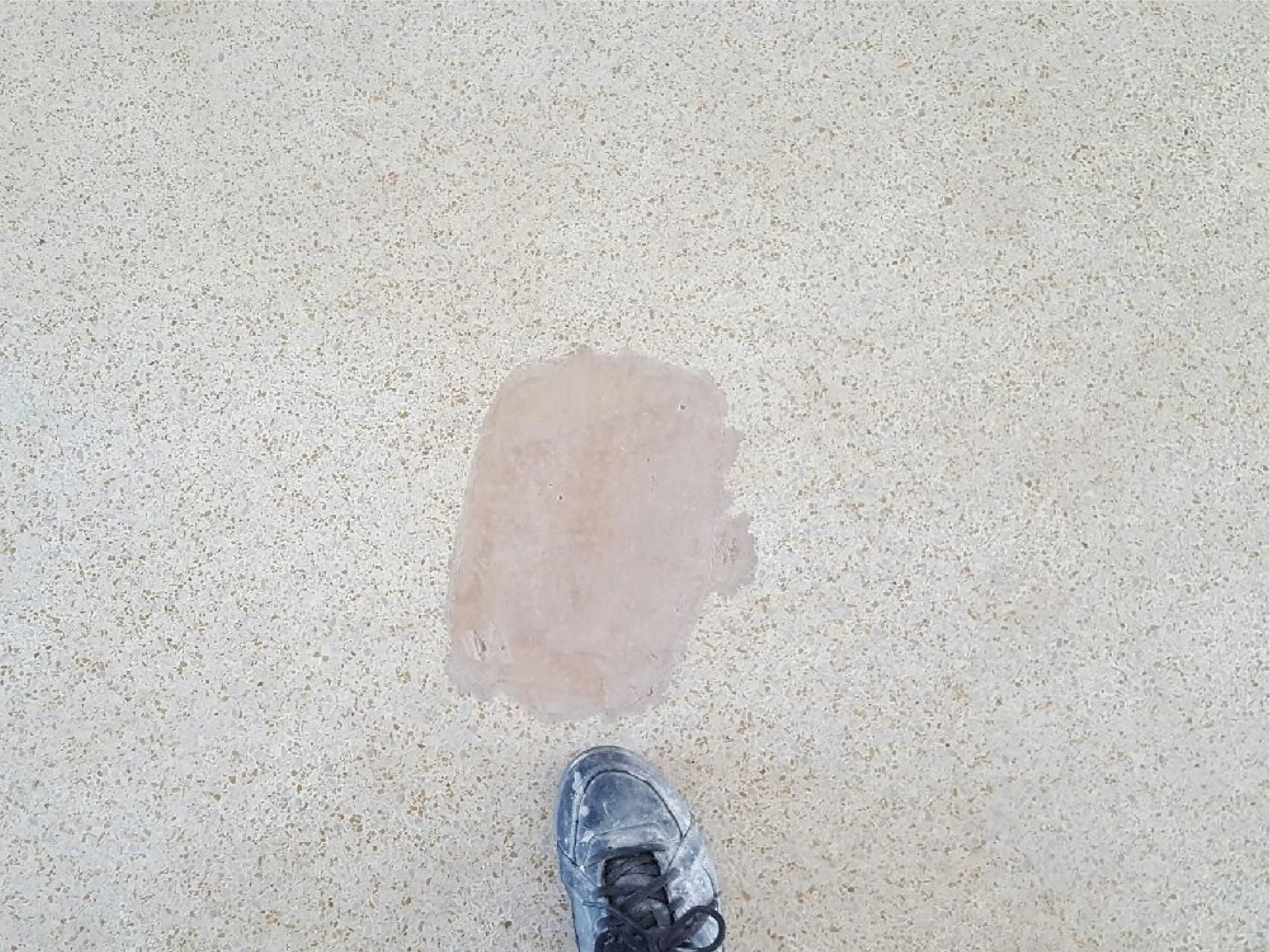 Worker shoe pointing at Terrazzo patchwork before